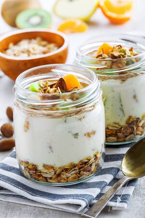Yogurt, granola and fruits in a jars for delicious breakfast. Traditional American healthy food.の写真素材