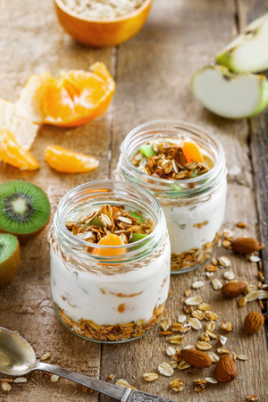 Healthy homemade granola with yogurt and fruits in a rustic jar. Traditional American food on a table. Classic snack. Top view.の写真素材