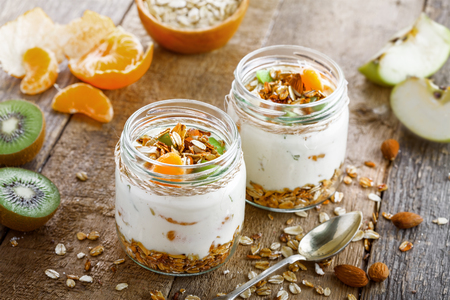 Healthy homemade granola with yogurt and fruits in a rustic jar. Traditional American food on a table. Classic snack. Top view.の写真素材
