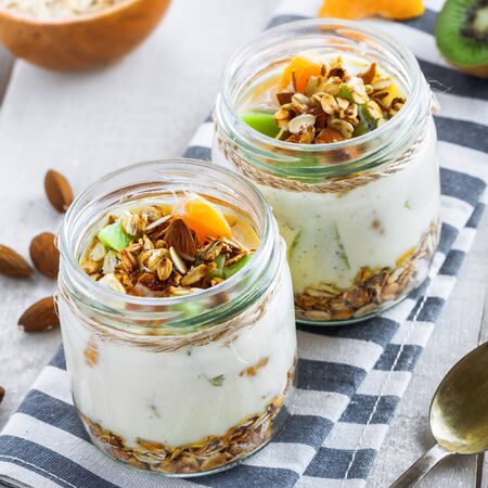 Healthy homemade granola with yogurt and fruits in a rustic jar. Traditional American food on a table. Classic snack. Top view.の写真素材