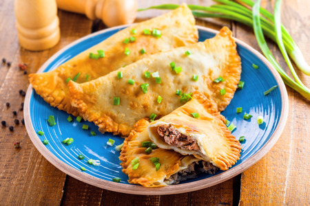East meat pastry cheburek. Traditional Russian, Ukrainian, Turkish and Tatar food on a table. Middle East native meat meal. Top view shot.の写真素材
