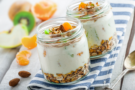 Granola with yogurt and fruits in a rustic jar. Delicious healthy American food for breakfast. Traditional US snack.の写真素材