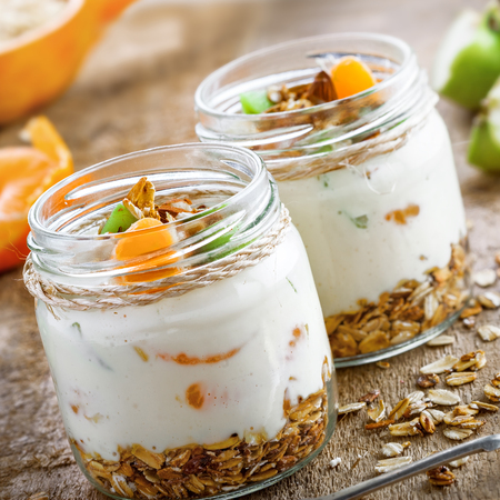 Granola with yogurt and fruits in a rustic jar. Delicious healthy American food for breakfast. Traditional US snack.の写真素材