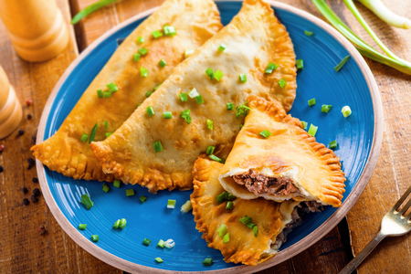 Chebureki with meat and spring onion. National Russian, Turkish, Ukrainian, Tatar and Romanian food on a table. Middle East traditional meat pastry. Top view.の写真素材