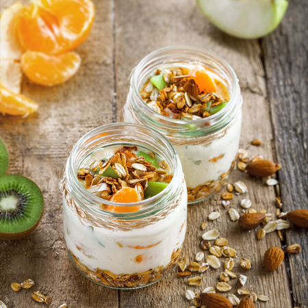Healthy homemade granola with yogurt and fruits in a rustic jar. Traditional American food on a table. Classic snack. Top view.の写真素材