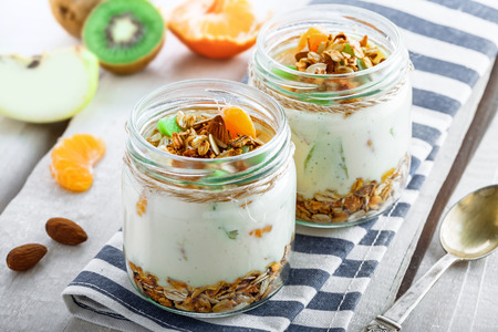 Granola with yogurt and fruits in a rustic jar. Delicious healthy American food for breakfast. Traditional US snack.の写真素材