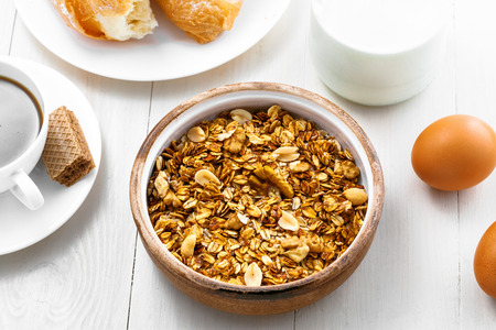 Granola, croissant, milk and fruits on a table. Healthy breakfast with coffee. International vegetarian meal. Top view.の写真素材