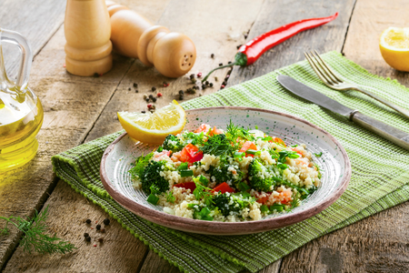 Healthy salad made of couscous, broccoli, tomato, pepper, onion and dill on a table. Traditional Moroccan food for healthy meal.の写真素材