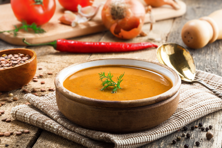 Lentil soup in a rustic bowl on a cotton canvas tablecloth. Healthy vegetarian food on an old wooden table.の写真素材