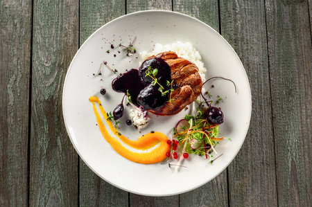 Delicious meat steak with rice, salad and sauce on a plate. Lunch healthy meal made of grilled meat and vegetable salad on a wooden table. Top view.の写真素材