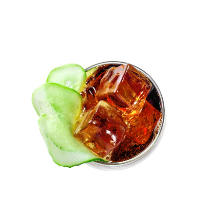 Delicious alcoholic cocktail drink with cucumber, cola and brandy isolated on white background. Classic cocktail with ice. Top view close-up shot.の写真素材