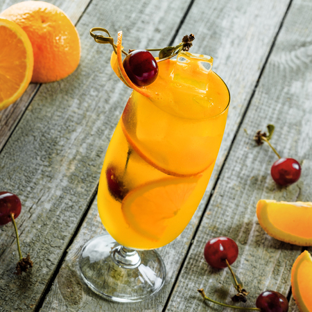Alcoholic punch cocktail made of fruits and alcohol in a long glass on a wooden table. Close-up shot.の写真素材