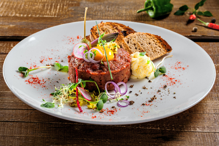 Tasty tartare with toasted bread and salad. Gourmet French meal made of raw ground meat. Delicious healthy food. Close-up shot.の写真素材