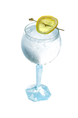 Glass gin and tonic cocktail with lemon slice isolated on a white background.の写真素材