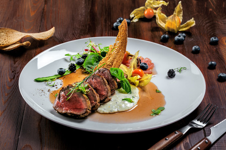 Tasty medium rare meat steak with sauce and salad. Gourmet meal made of meat fillet and vegetables. Delicious healthy food.の写真素材