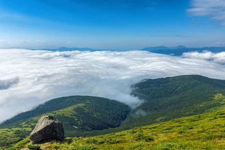 Landscape of mountain in a clouds and rock on foreground. Carpathian Mountains in a summer sunny day.の写真素材