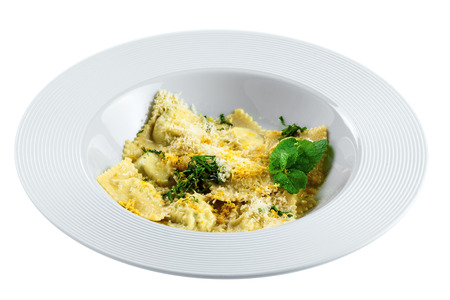 Ravioli filled with ricotta, mint and grated lemon rind isolated on white background. Classic Italian cuisine pasta meal in a soup plate.の写真素材