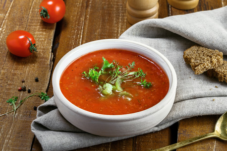 Delicious gazpacho and ingredients on a table. Vegetarian vegetable cold soup.の写真素材