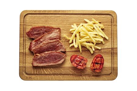 Medium rare sirloin steak with chips and grilled tomatoes isolated on white background. Classic European lunch studio flat lay shot. Top view, directly above.の写真素材