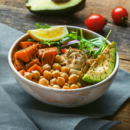 Bowl of chickpeas, salad, sweet potato, salad and avocadoの写真素材