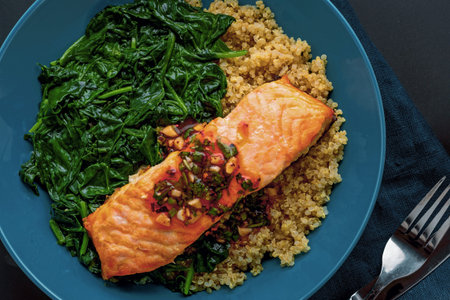 Baked Salmon Fillet on Bed of Quinoa and Wilted Spinach. Flat Lay.