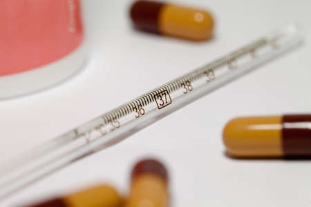 Mercury termometer and some capsules isolated on whiteの写真素材