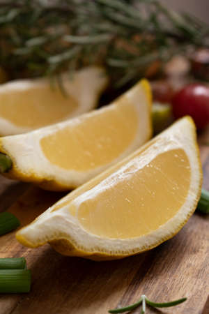 Lemon slices on wooden board with cherry tomatoes. Fresh fruits for diet, with rosemary.の写真素材