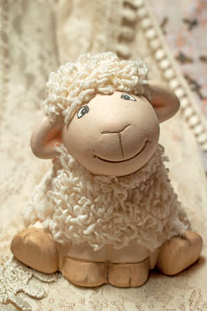 White sheep toy on a lace. Cute toy sheep. Fury toy, sweet and cute, for kids.の写真素材