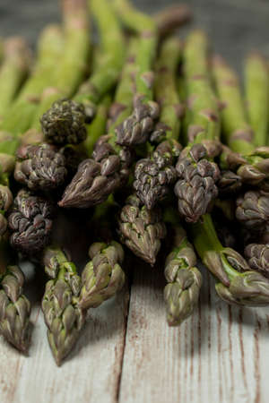 Lots of asparagus, fresh vegetables on a wooden desk.の写真素材