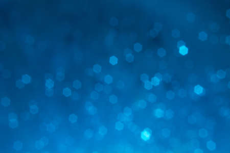 Bokeh particles on dark blue backgroundの写真素材