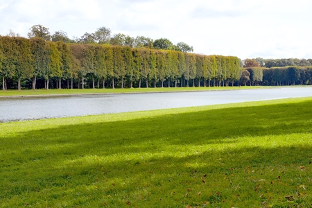 Photo shows French green garden with flowers and monuments.の写真素材