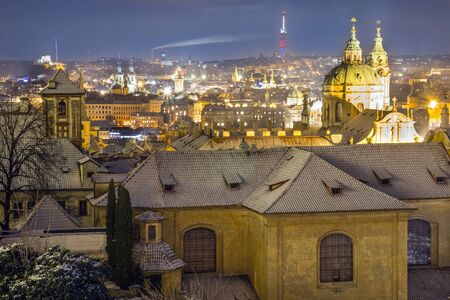 Photo shows old city houses with snowy roofs during winter at night.の写真素材