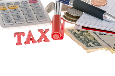 This photo shows a closeup of tax sign, calculator, marker, banknotes, coins and paper on white background.の写真素材