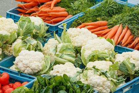 Photo shows close-up of various vegetable items on farmer market in plastic boxes during a day.の写真素材
