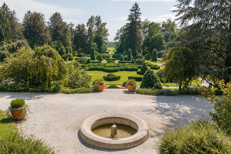 Photo shows landscape view of green garden with flowers and trees.の写真素材
