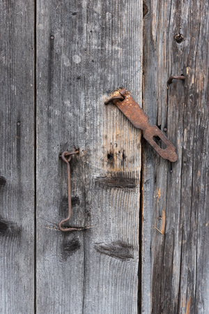 The old door locked with a padlock hanging brackets. At an angle.の写真素材