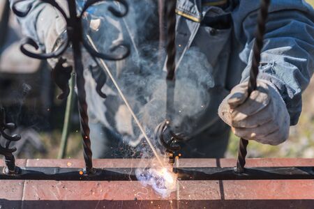 A worker welding metal handrails on the stairs. Ukraine.の写真素材