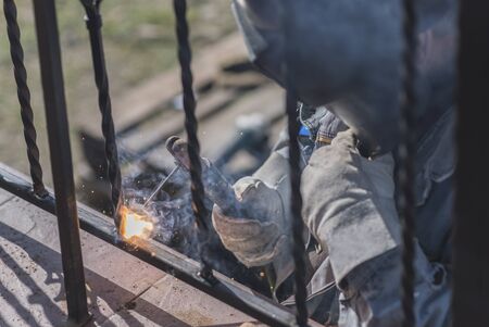 A worker welding metal handrails on the stairs. Ukraine.の写真素材