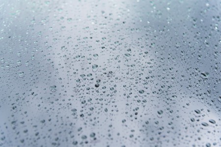 Raindrops on glass, spectacular sky background with some blurの写真素材