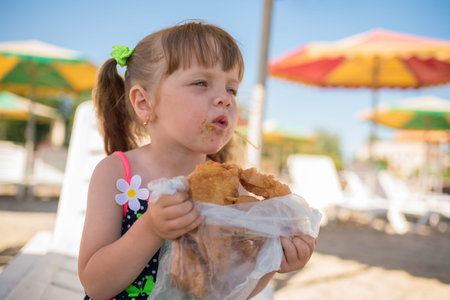The little girl eats baklava, dirty face, summer vacation