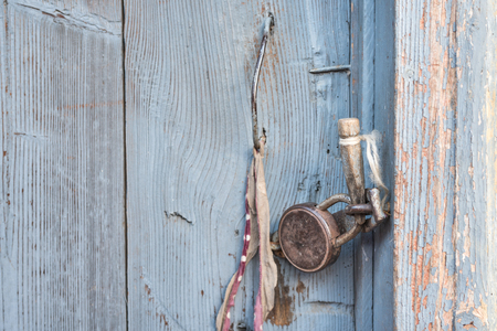 Door closed by retro padlock and blade fixed, fragment of wooden surface, wooden doors, cracked paint, cracks, knuckles, nails, textures and backgrounds, copy spaceの写真素材