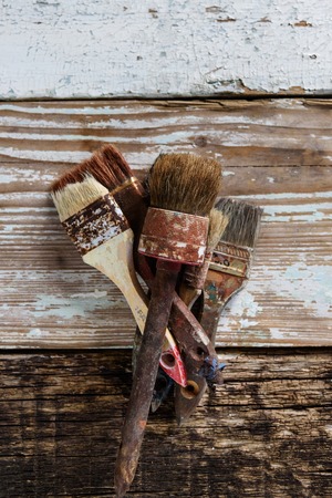 Set of used brushes on a wooden surface with, retro and vintage objects, text placeの写真素材
