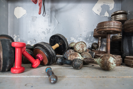 Concept - healthy lifestyle. Old retro dumbbells are lying on the floor in a boxing gym, sports gear, copyspaceの写真素材