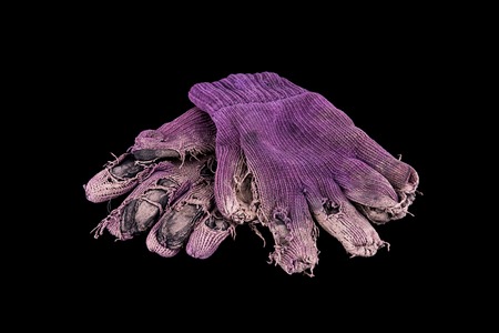 Pair of shabby mittens on black background. Concept - hard workの写真素材