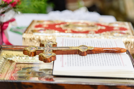 The decorated wooden Cross, the prayer book, the icon and the Bible on the altar in the Christian templeの写真素材