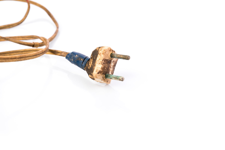 Damaged power plug wrapped with insulation tape, white background with copy space for text. Concept - neglect of fire safetyの写真素材