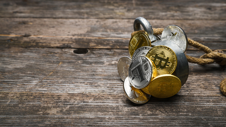 Group of golden and silver Bitcoin Ethereum Litecoin are caught by magnet, on wooden surface, business concept, banner 16x9 format with copy space for textの写真素材