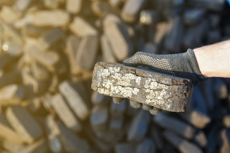 Sample of peat briquette in hand, alternative fuels, raw materialの写真素材