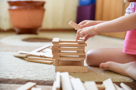Child sits on carpet and play game, child toys, children development and leisure, closeupの写真素材