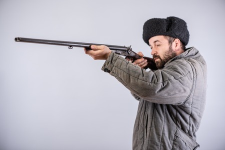 Hunter took the target, horizontal double-barreled shotgun in hands, studio shotの写真素材